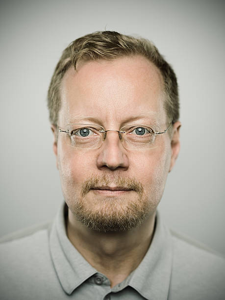 Portrait of a swedish real man Portrait of a real scandinavian man with neutral expression. Short blond hair, glasses, blue eyes and facial hair. Around 50 years old swedish. Vertical color image from a dslr camera in studio. scandinavian descent photos stock pictures, royalty-free photos & images