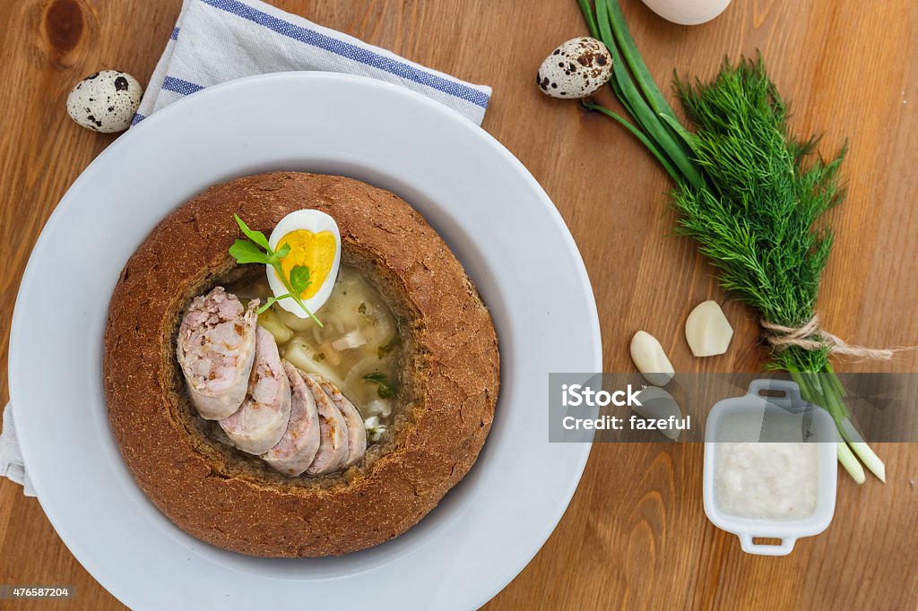 traditional white borscht with sausage, egg in bread traditional white borscht zurek with sausage,egg and mushrooms in bread as bowl 2015 Stock Photo