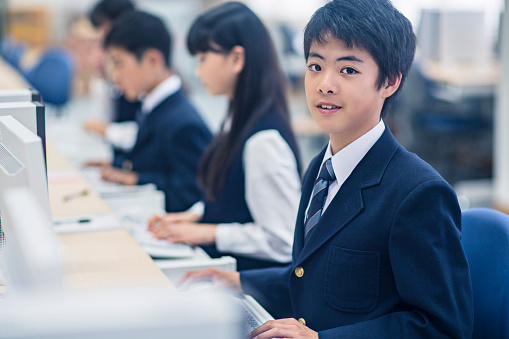 Japanese boy in the Computer Class looking at the camera.