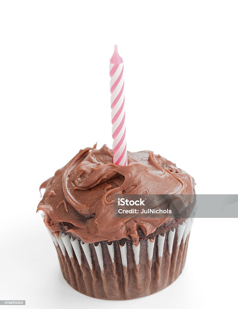 Pink Candle on Chocolate Cupcake Chocolate cupcake with chocolate icing and pink candle. Studio isolated with a light shadow. Anniversary Stock Photo
