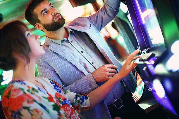 istock Couple playing slots in casino. 476595430