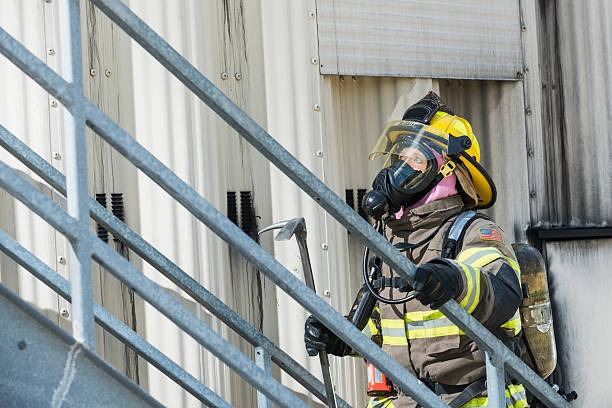 istock Female firefighter in protective gear and oxygen mask 476596064