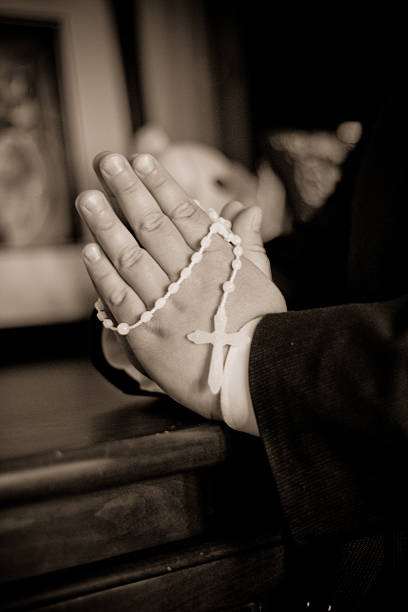 istock Child Praying with a Rosary Around his Hands. 476601318