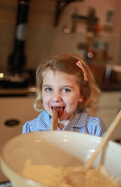 istock Young girl who has been baking liking the spoon. 476601342