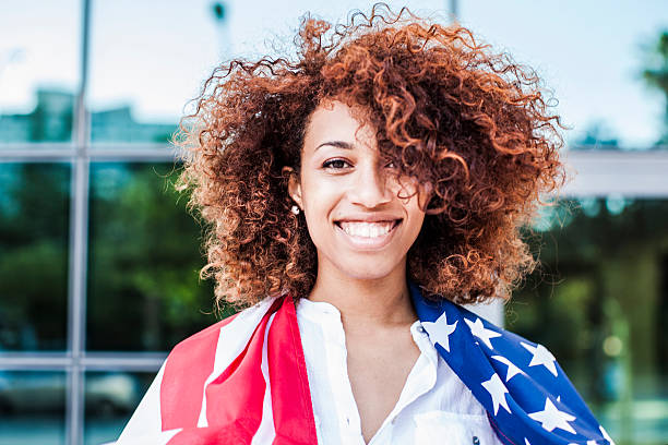 istock Beautiful afro woman holding US flag 476603936