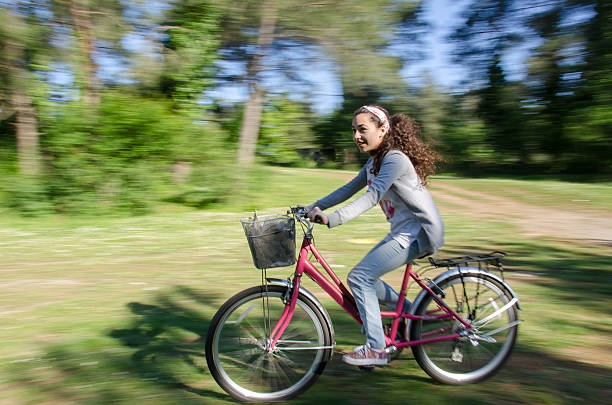 girl cycling on the forest way