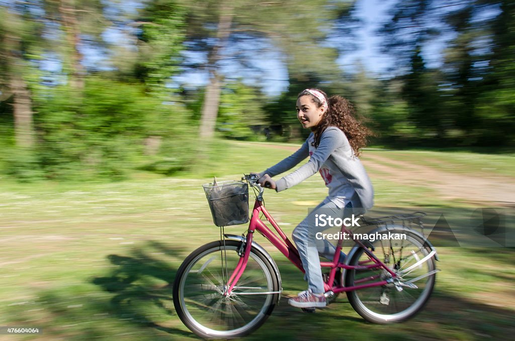girl cycling on the forest way Cycling Stock Photo