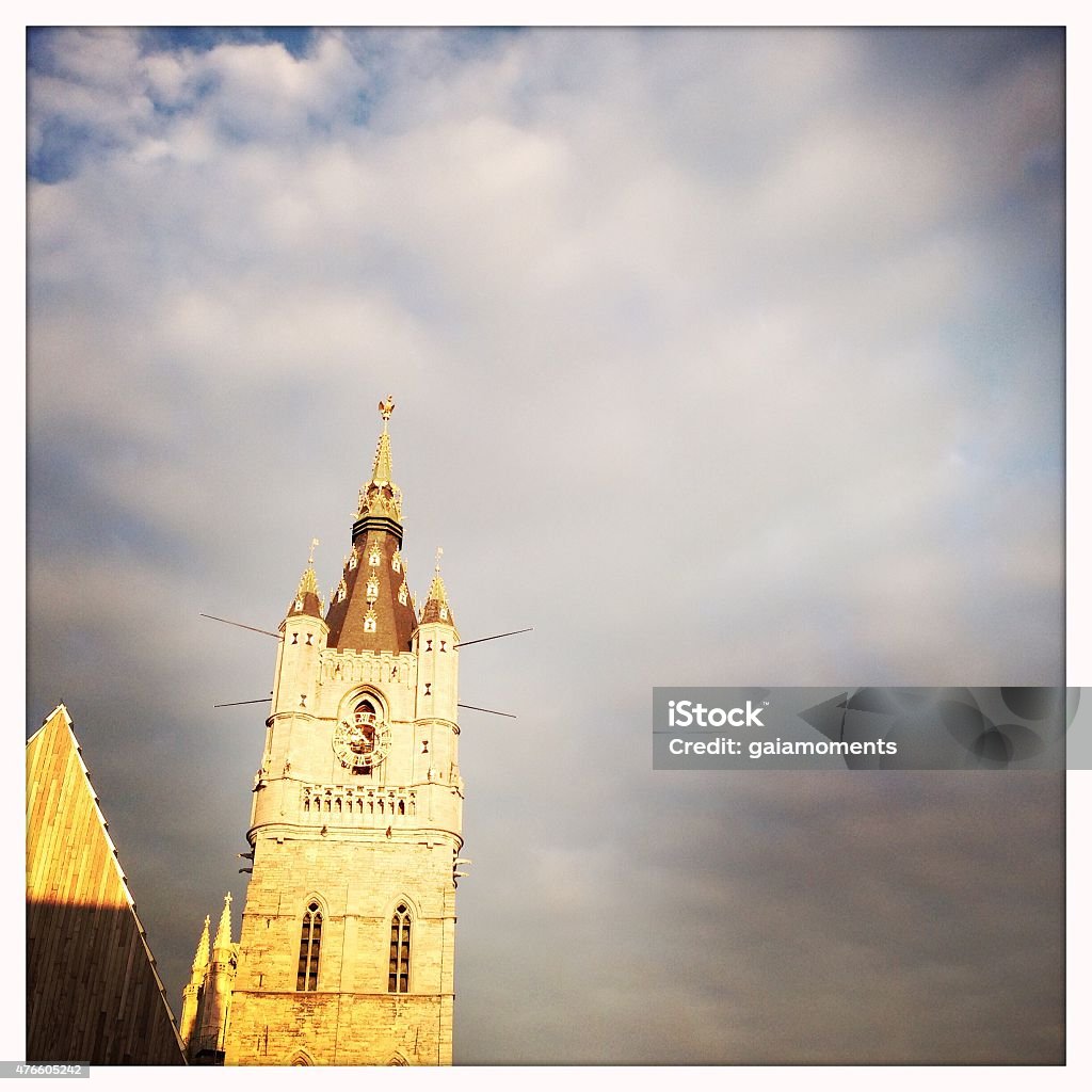 Belfry of Ghent The 91-metre-tall belfry of Ghent photographed from the street below. Construction of the tower began in 1313 after a design by master mason Jan van Haelst. His plans are still preserved in the Ghent City Museum. 2015 Stock Photo