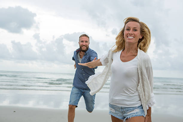 istock Playful couple running on the beach 476608380