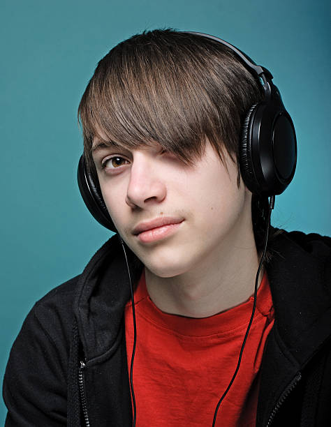 Teenager Teenager in headphones is listening to music emo boy stock pictures, royalty-free photos & images