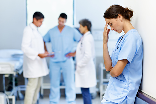 Shot of an exhausted doctor leaning against a wall with colleagues in the backgroundhttp://195.154.178.81/DATA/i_collage/pu/shoots/804719.jpg