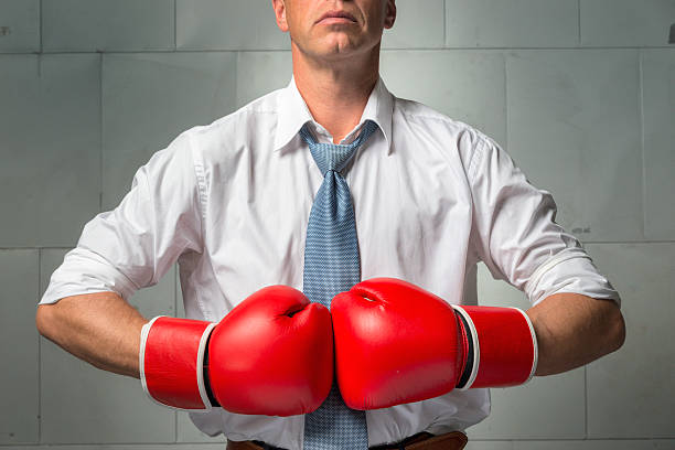 homme d'affaires, vêtu d'une chemise blanche, une cravate et gants de boxe - boxing glove battle business fighting photos et images de collection