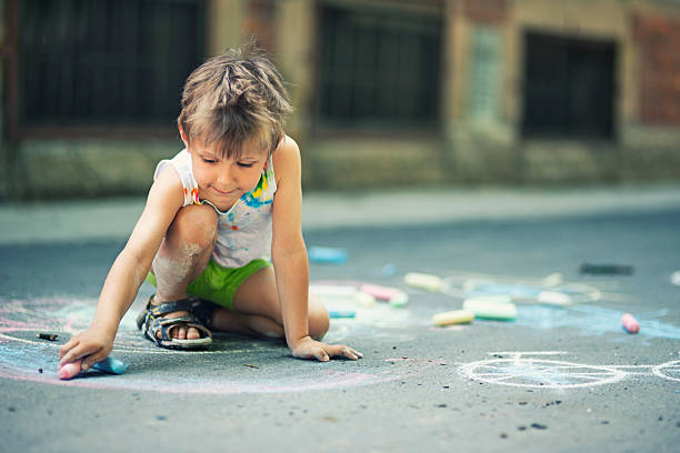 istock Little boy chalking on the street 476613852