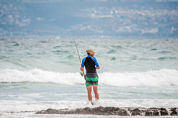 Angler at a beach in Reebok Mosselbay, South Africa - December 29, 2014: Unidentified angler at a beach in Reebok near Mosselbay, South Africa reebok stock pictures, royalty-free photos & images