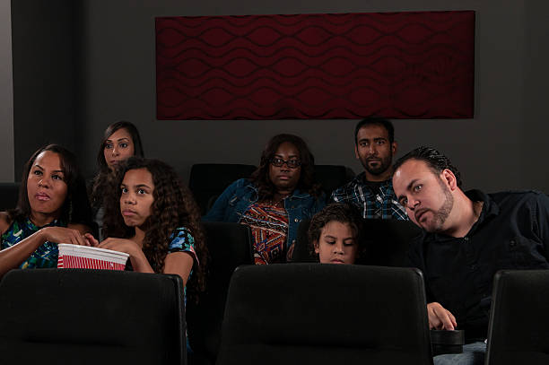 istock Father in theater telling son to put electronic away 476618402