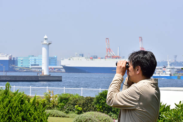 Men of Japan overlooking the sea with binoculars