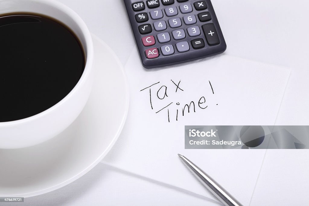 Tax Time Tax Time written on a napkin next to coffee cup Adhesive Note Stock Photo