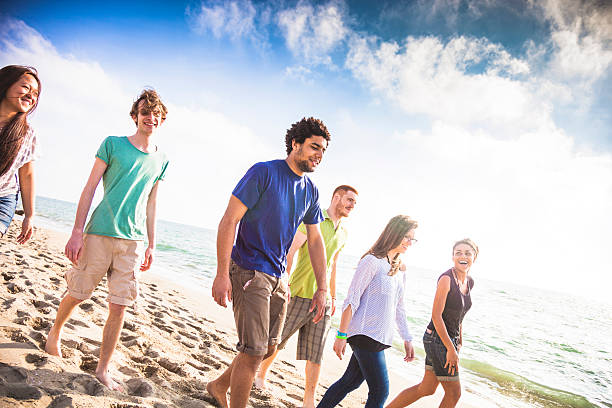 istock Group of friends walking on the beach during vacation 476621118