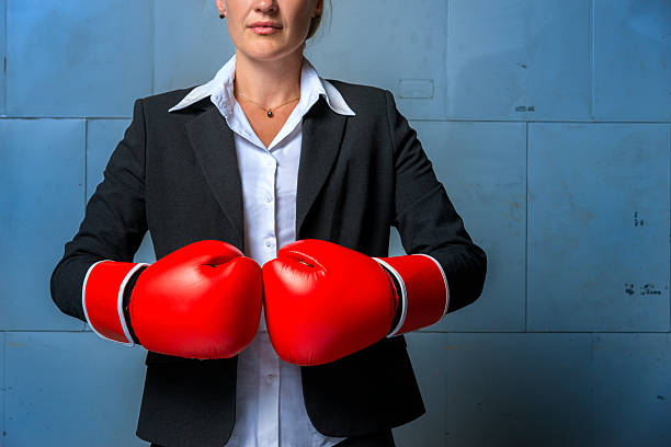 ビジネスの女性が着用のスーツ、レッドのボクシンググローブ - boxing glove conflict rivalry fighting ストックフォトと画像