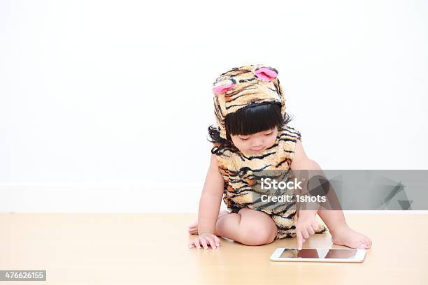 Photo libre de droit de Asiatique Petite Fille En Costume De Tigre Avec Tablette Électronique banque d'images et plus d'images libres de droit de 12-17 mois