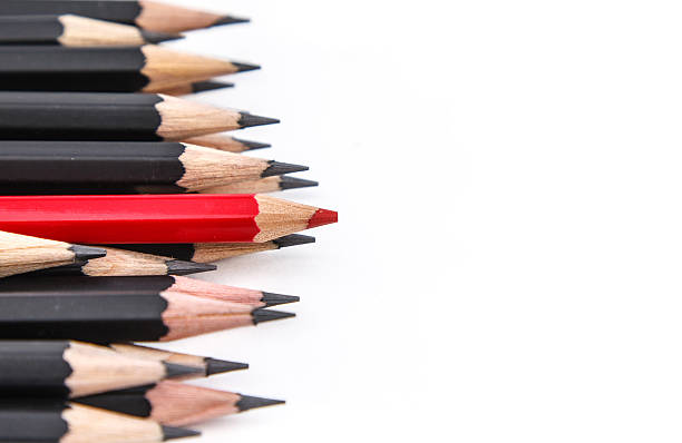 istock Red pencil against black pencils 476627271