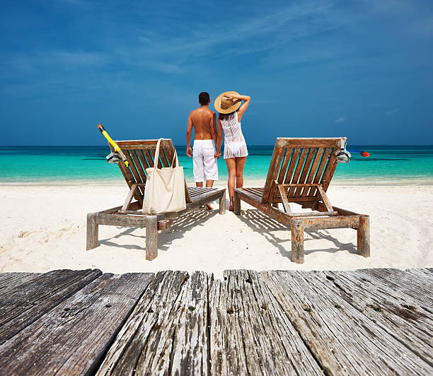 istock Couple in white relax on a beach at Maldives 476627618