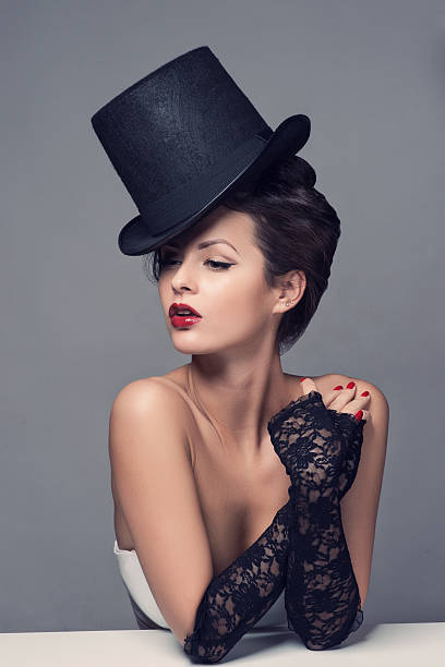 Superb and vain woman personifies Stereotypical, personified image of an arrogant, vain woman: wearing a top hat, white shirt, necktie, dismissively blowing on her manicure, mocking us. She isn't just
