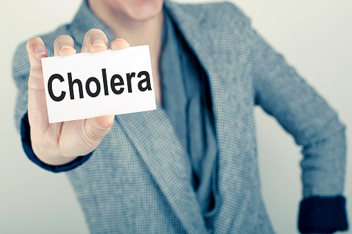 Hand holds card with Cholera text.