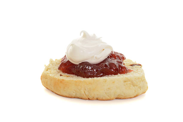 english scone with jam and cream on white 