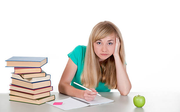 istock tired female student sits at table with books 476630641