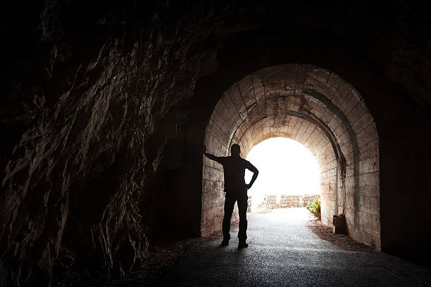 istock Young man stands relaxed in dark tunnel 476630643
