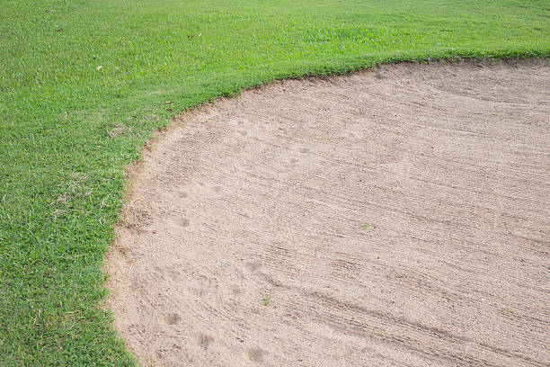 istock sand bunker and green grass of golf course 476631586
