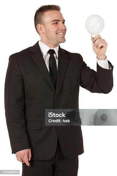 Geschäftsmann Holding Eine Glühbirne Stockfoto und mehr Bilder von Anzug - Anzug, Bürojob, Dreiviertelansicht