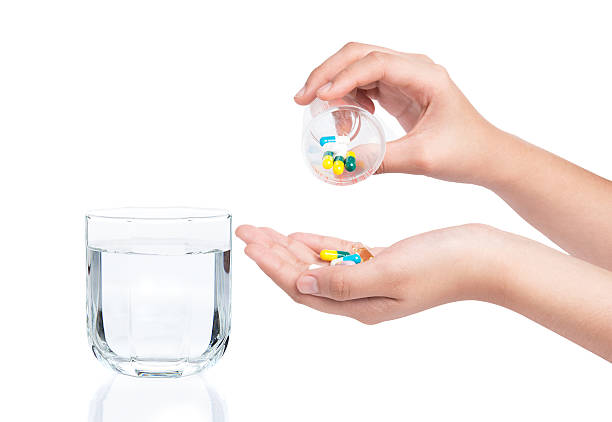 istock Drug capsules and pills in hand with drinking water 476637802