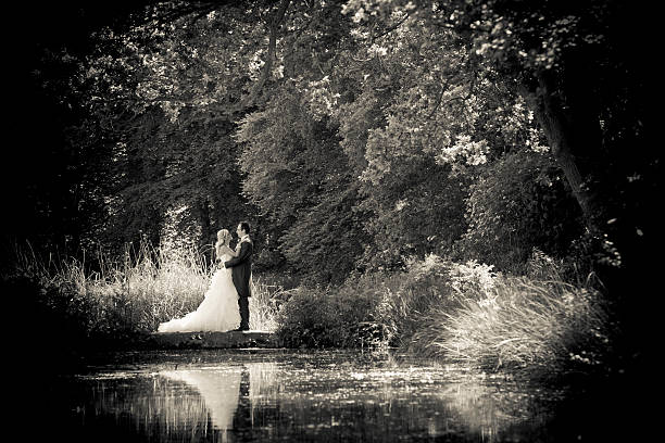 Bride and groom holding with reflection during summers day stock photo