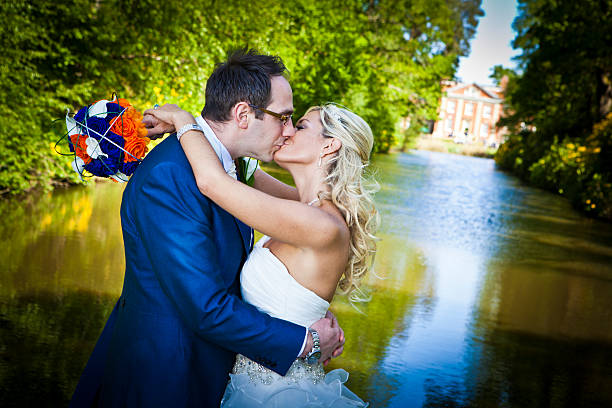Bride and groom in a loving embrace and kissing stock photo