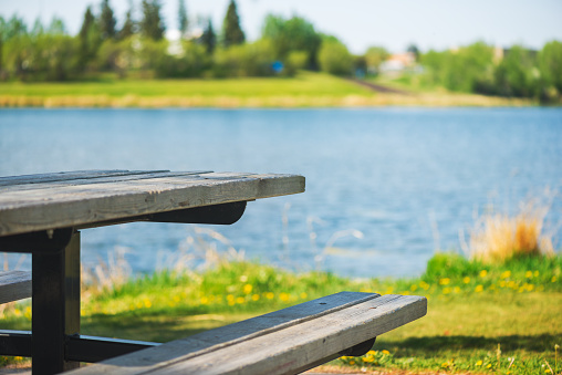 A picnic table near a lake on a warm summer day