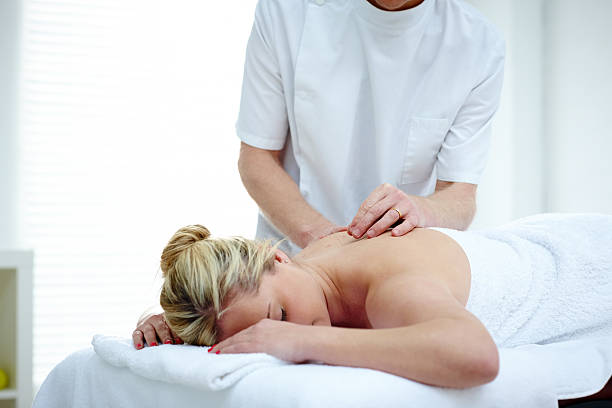 Performing acupuncture on a patients back.A close-up of a patient receiving acupuncture an treatment on the back.Acupuncture back treatment.
