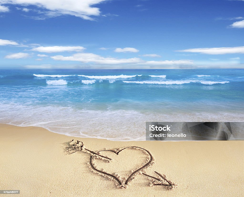 Heart with arrow, as love sign, drawn on the beach. Heart with arrow, as love sign, drawn on the beach shore, with the see and sky in the background. Backgrounds Stock Photo