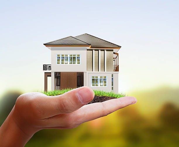 istock Businessman holding house model 476649640