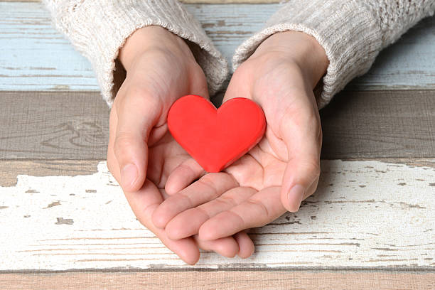 istock Red heart in feamale hands 476655950