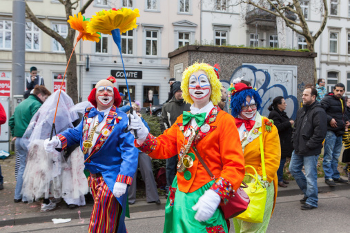 Wiesbaden, Germany - March 2, 2014: Carnival 2014. A carnival parade moves through the streets of Wiesbaden, Germany, in the foreground some colourful costumed participants - waving and cheering. In the background some spectators