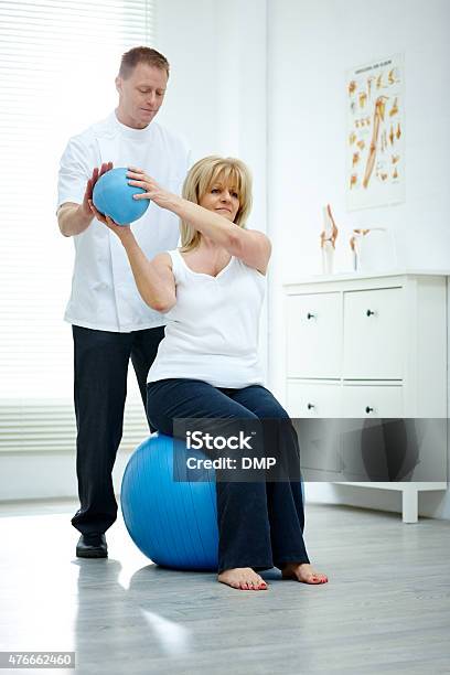 Physical Therapist Assisting Senior Woman At Medical Gym Stock Photo - Download Image Now