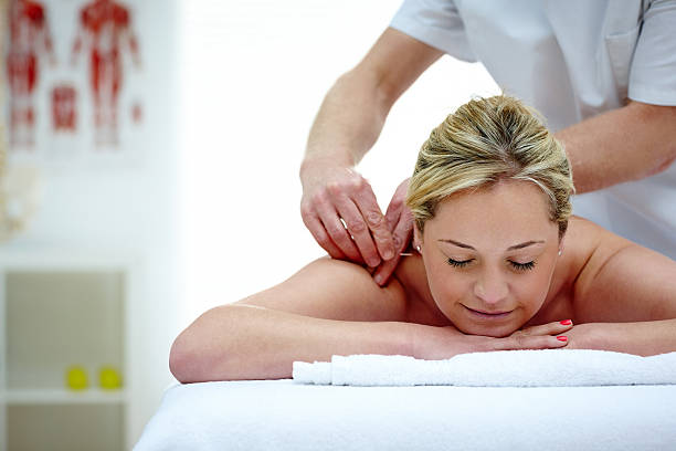Performing acupuncture on a patients back.A close-up of a patient receiving acupuncture an treatment on the back.Acupuncture back treatment.