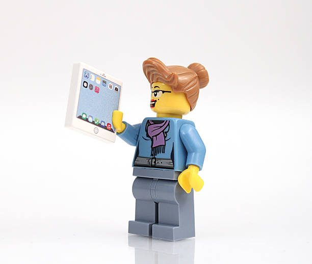Lego Businesswoman with Tablet Colorado, USA - June 7 2015: Studio shot of Lego businesswoman with tablet. Legos are a popular line of plastic construction toys manufactured by The Lego Group, a company based in Denmark. lego stock pictures, royalty-free photos & images