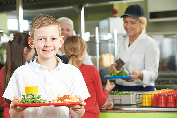 male pupil with healthy lunch in school cafeteria - schoollunch stockfoto's en -beelden