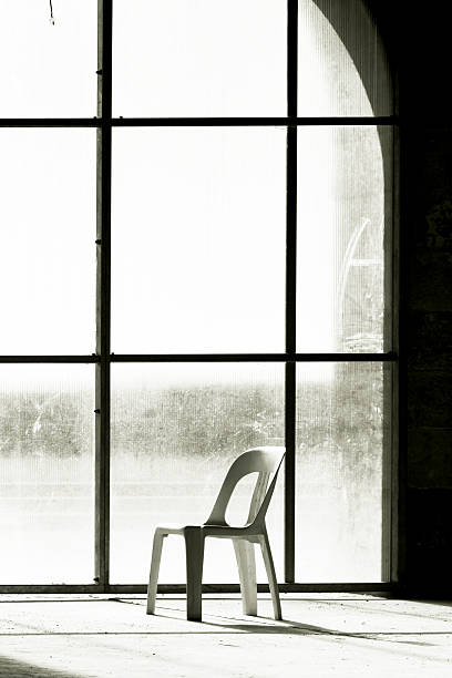 istock Plastick chair in abandoned building with large window, copy space 476665984