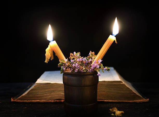 istock Two burning candles with book in the darkness 476670288