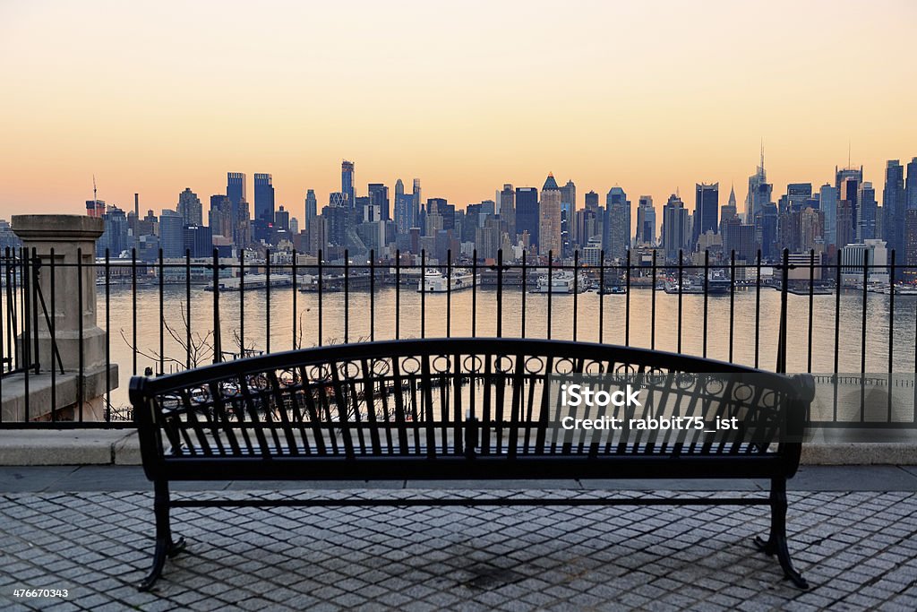 New York City Bench in park and New York City midtown Manhattan at sunset with skyline panorama view over Hudson River Architecture Stock Photo