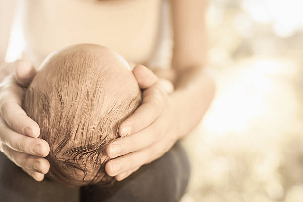 istock Mother holding baby head at hands 476671116